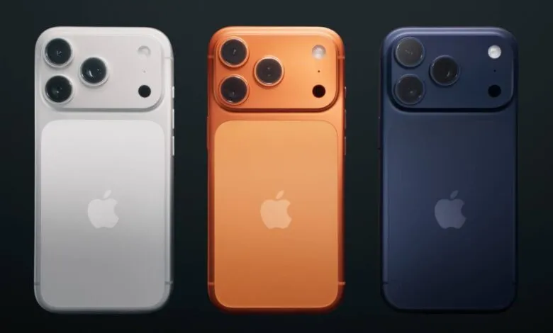 Three iPhones in white, orange, and blue showing the rear camera setup.