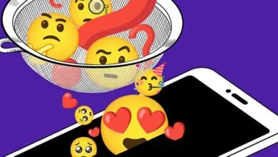 Emojis in a strainer above a phone screen, conveying digital emotions.