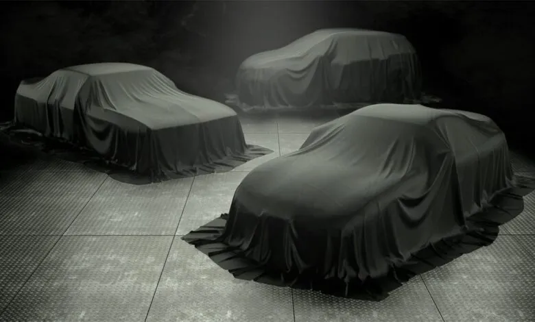 Three cars under black silk sheets on a diamond-plated floor.