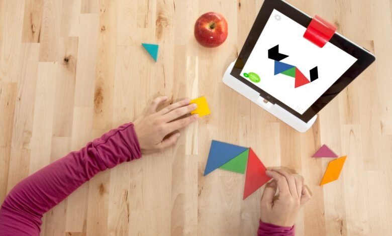 Child playing tangram puzzle game on tablet with wooden pieces.