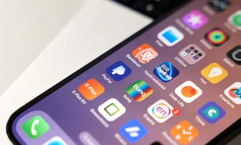 iPhone 14 Pro screen displaying various app icons, including finance and utility apps.