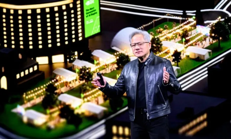 Jensen Huang presents at GTC, holding device, thumbs up.