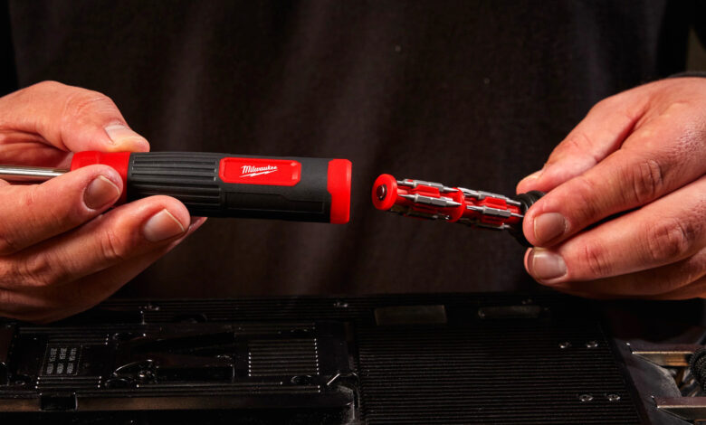Hands connect Milwaukee screwdriver bit set above electronic device.