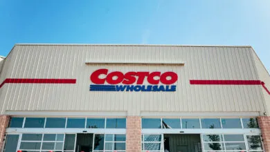 Exterior view of a Costco Wholesale store under a clear blue sky.