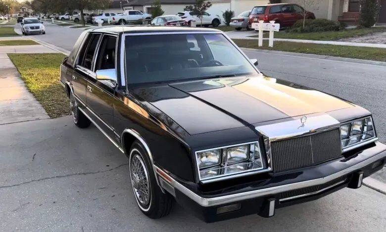 Black Chrysler Fifth Avenue parked on a residential street.