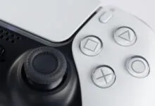 Close-up of a white and black PlayStation 5 DualSense controller.