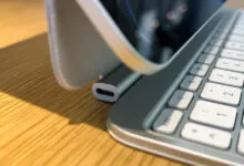 Close-up of a tablet with a keyboard case on a wooden surface.