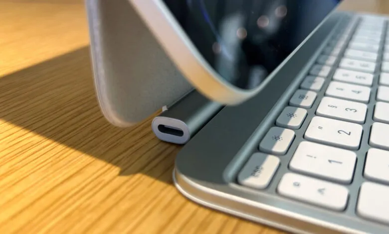 Close-up of a tablet with a keyboard case on a wooden surface.