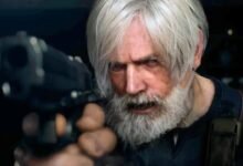 Stern man with white hair and beard points a handgun directly forward.