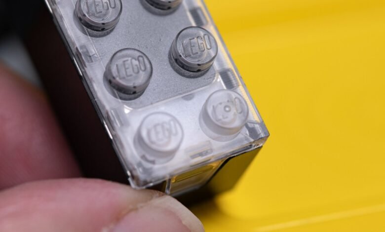 Close-up of a clear LEGO brick with the LEGO logo on the studs.