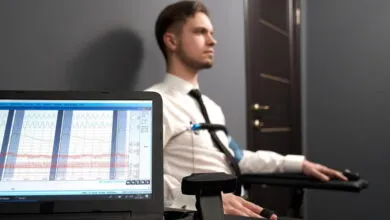 Man undergoing lie detector test with visible pulse diagrams on computer.