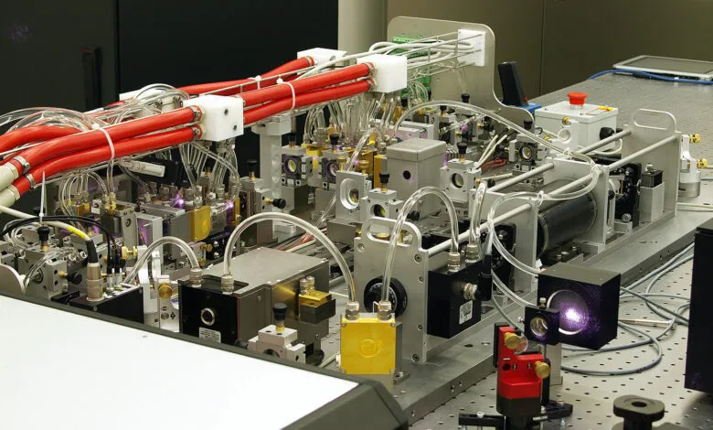 Complex laser system with red tubes, silver components, and optical elements.