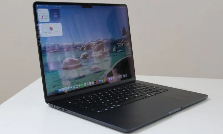 Open black MacBook Air laptop displaying a scenic lake wallpaper.