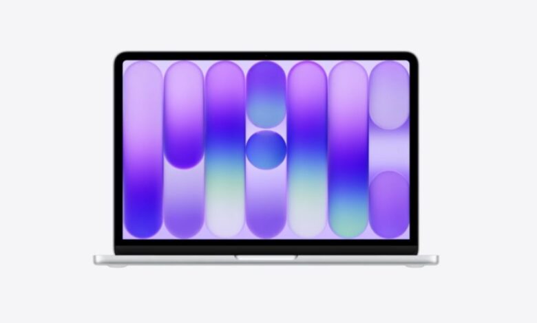 Silver MacBook displaying a vibrant purple and blue abstract wallpaper.