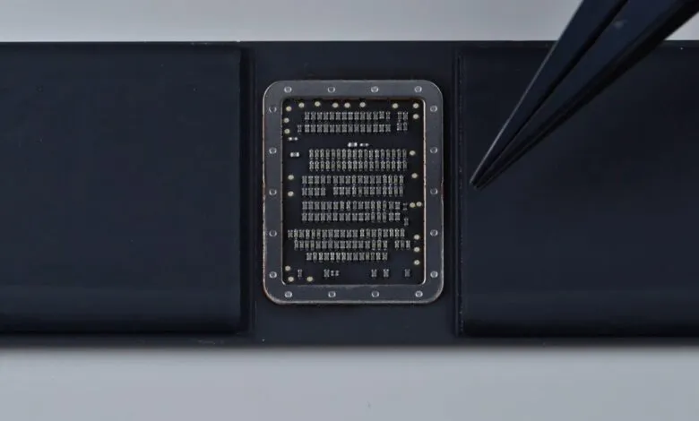 Close-up of a microchip being handled with tweezers.