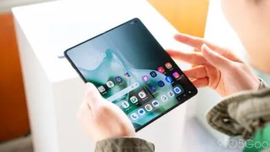 Person holding a Motorola Razr foldable phone displaying the home screen.