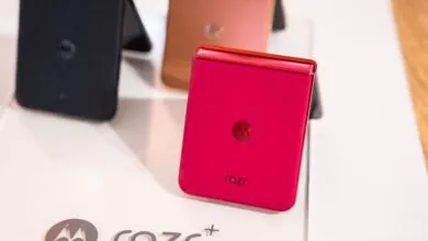 Closed red Motorola Razr+ foldable phone on display stand.