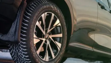 Close-up of a Nokian Hakkapeliitta 01 winter tire on a car, showing tread and wheel.