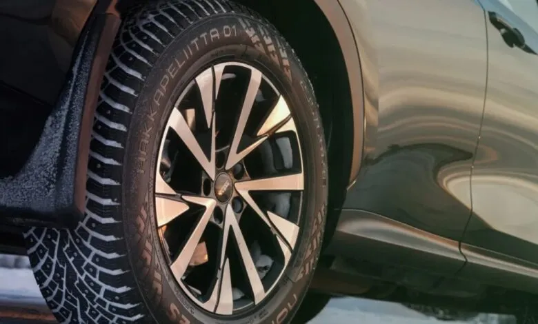Close-up of a Nokian Hakkapeliitta 01 winter tire on a car, showing tread and wheel.