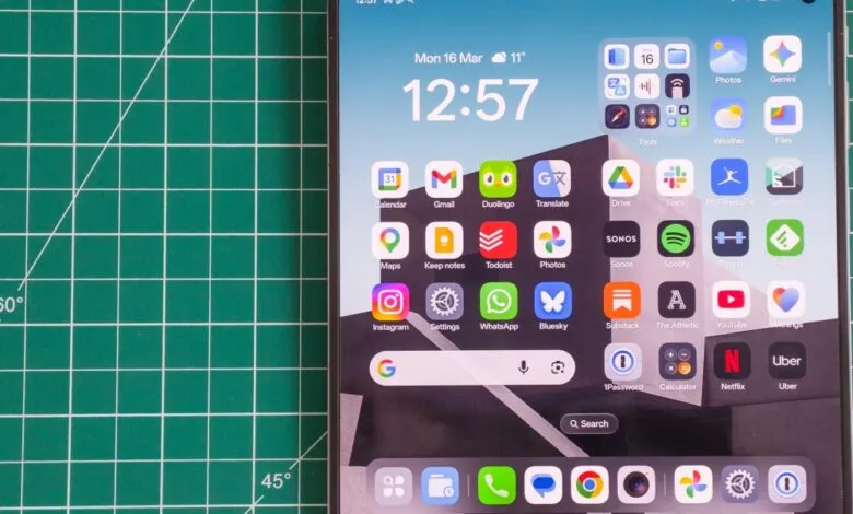 Smartphone screen displaying app icons and widgets on a green cutting mat.