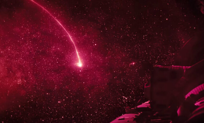 Red space scene with a bright streak resembling a shooting star.