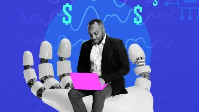 Person using laptop while sitting on a robot hand with dollar signs.