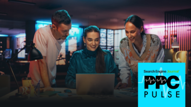 Three colleagues collaborate on a laptop in a modern, neon-lit office.