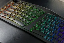 Ergonomic Razer keyboard with rainbow LED backlighting and wrist rest.