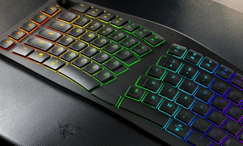 Ergonomic Razer keyboard with rainbow LED backlighting and wrist rest.