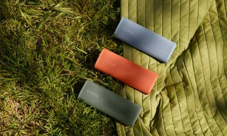 Three colorful Sonos Roam speakers on a green blanket outdoors.