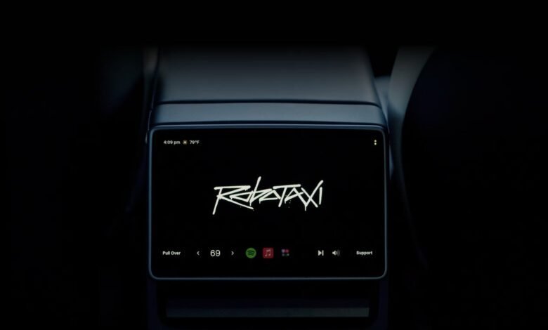 Rear screen displaying 'Robotaxi' with music controls and time/temperature.