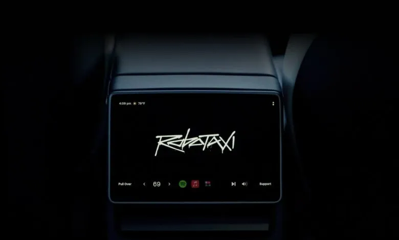 Rear screen displaying 'Robotaxi' with music controls and time/temperature.