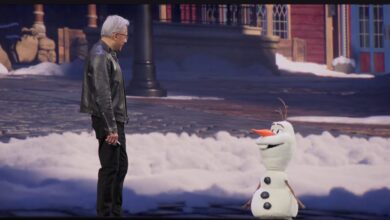 Jensen Huang stands next to Olaf from Frozen on a stage.