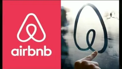 Airbnb logo on red background next to finger drawing logo on foggy glass.
