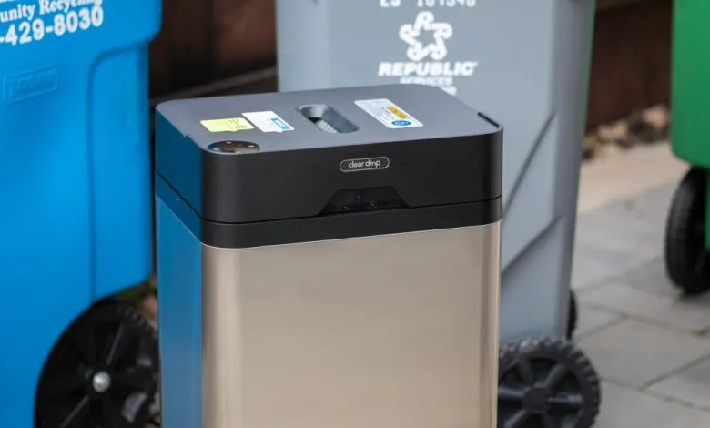 Clear Drop automatic trash can with blue, gray, and green recycling bins.