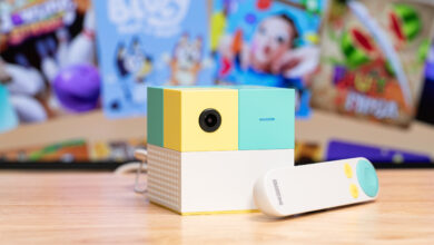 Colorful projector with remote on a wooden surface.