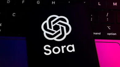 OpenAI Sora logo on a smartphone screen atop a laptop keyboard.