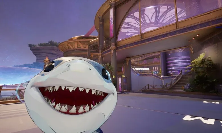 Cartoon shark head with open mouth in front of futuristic building.