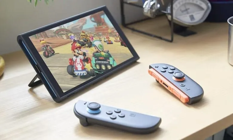 Nintendo Switch displaying Mario Kart game with Joy-Cons on desk.