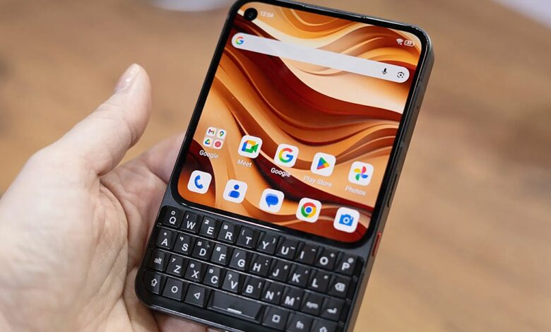 Hand holding a Unihertz smartphone with a physical QWERTY keyboard.