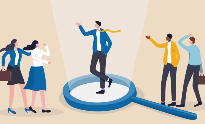 Person stands in spotlight on magnifying glass, others look on.