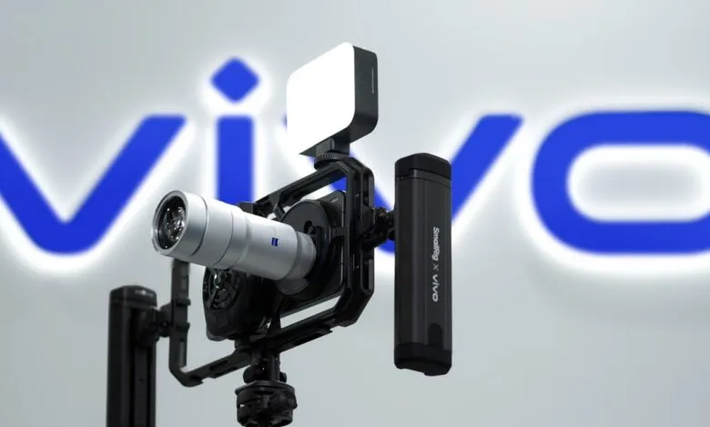 Vivo phone in camera cage with lens, light, and battery pack.