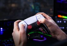 Hands hold a PlayStation 5 controller while gaming.