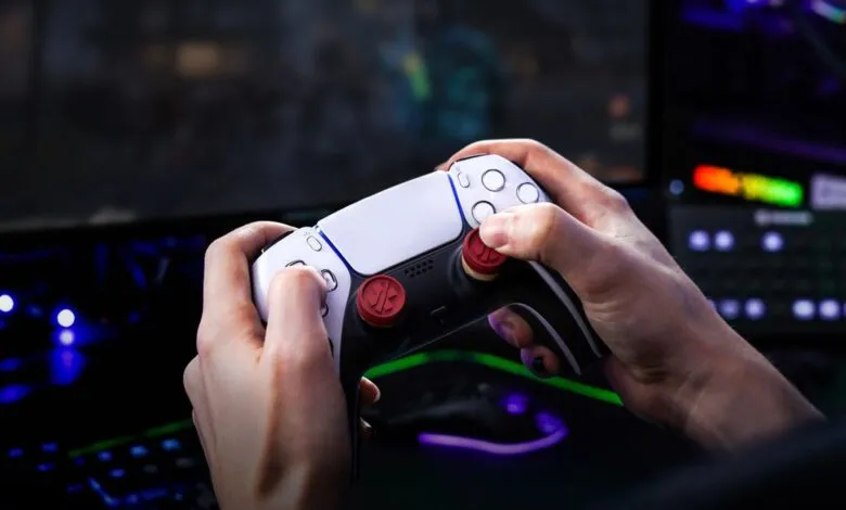 Hands hold a PlayStation 5 controller while gaming.