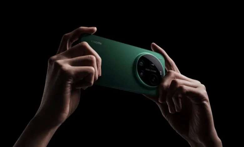 Hands holding a green Xiaomi smartphone with Leica camera on a black background.