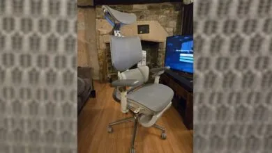 Ergonomic office chair with headrest and adjustable arms in a living room setting.
