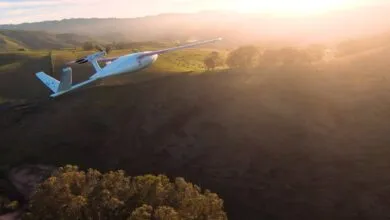 Zipline drone flying over hilly landscape at sunset, delivering medical supplies.