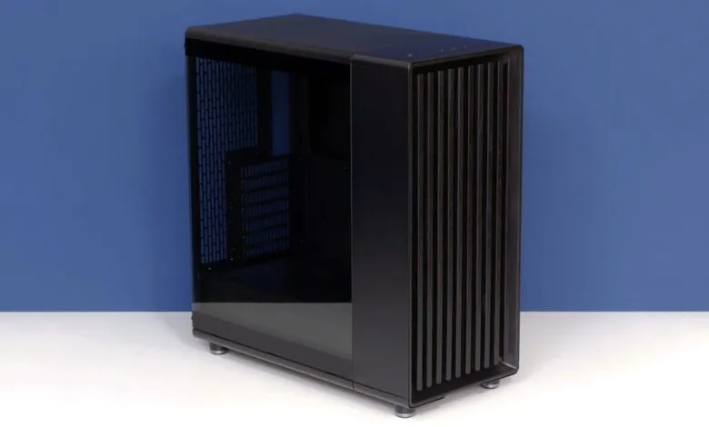 Black computer case with tempered glass side panel on white surface.