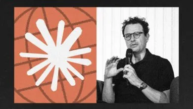 Man with glasses speaking into a microphone next to a globe graphic.