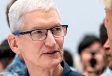 Close-up of Tim Cook, Apple CEO, wearing blue glasses.